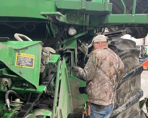 IMI Equipment LLC mechanic working on tractor