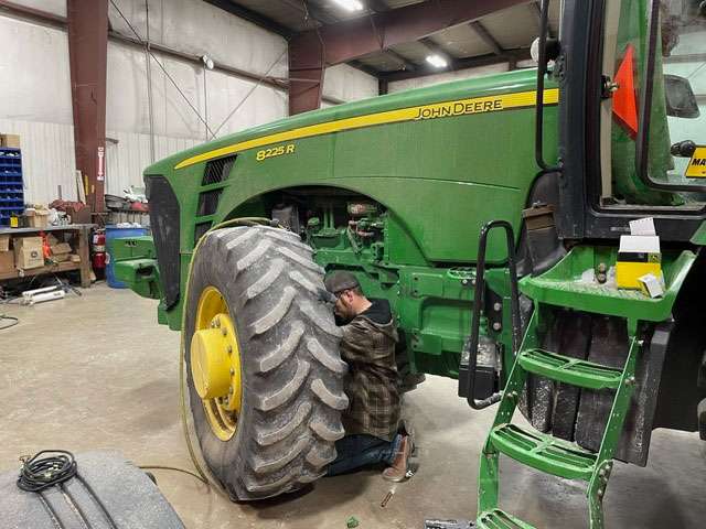 IMI Equipment LLC mechanic working on tractor