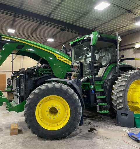 IMI Equipment LLC mechanic working on tractor